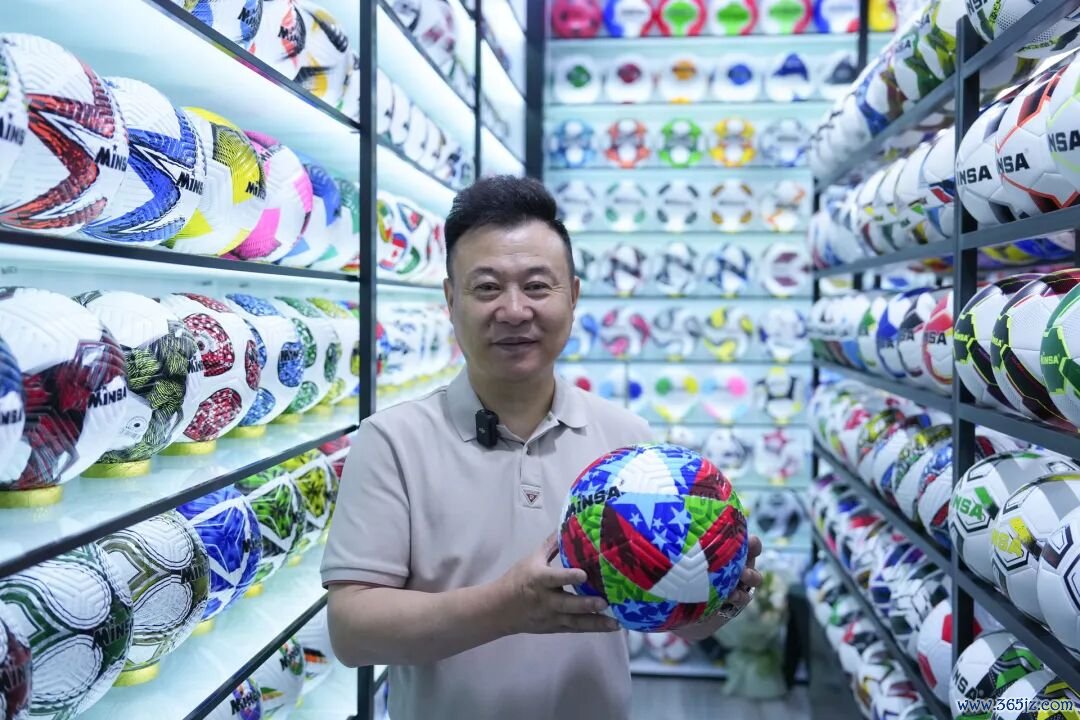 陈绍好意思展示自主缱绻出产的热销足球。图片开始：新华社